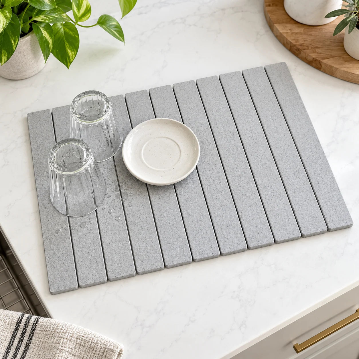 Pebble Grey stone drying mat with rinsed glasses and a saucer